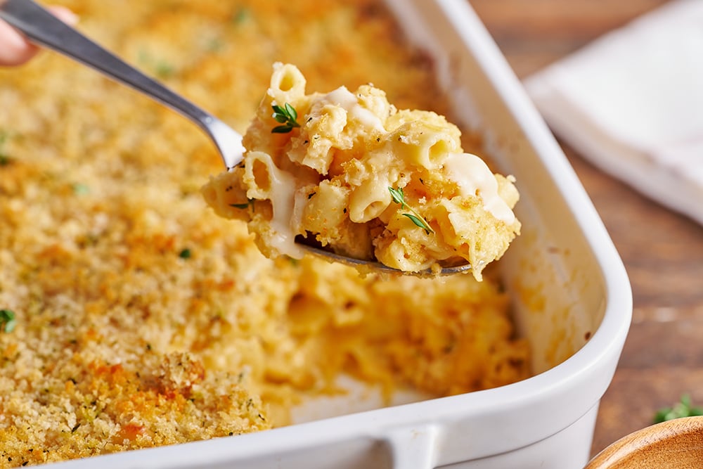 macaroni and cheese recipe being served with a large serving spoon.