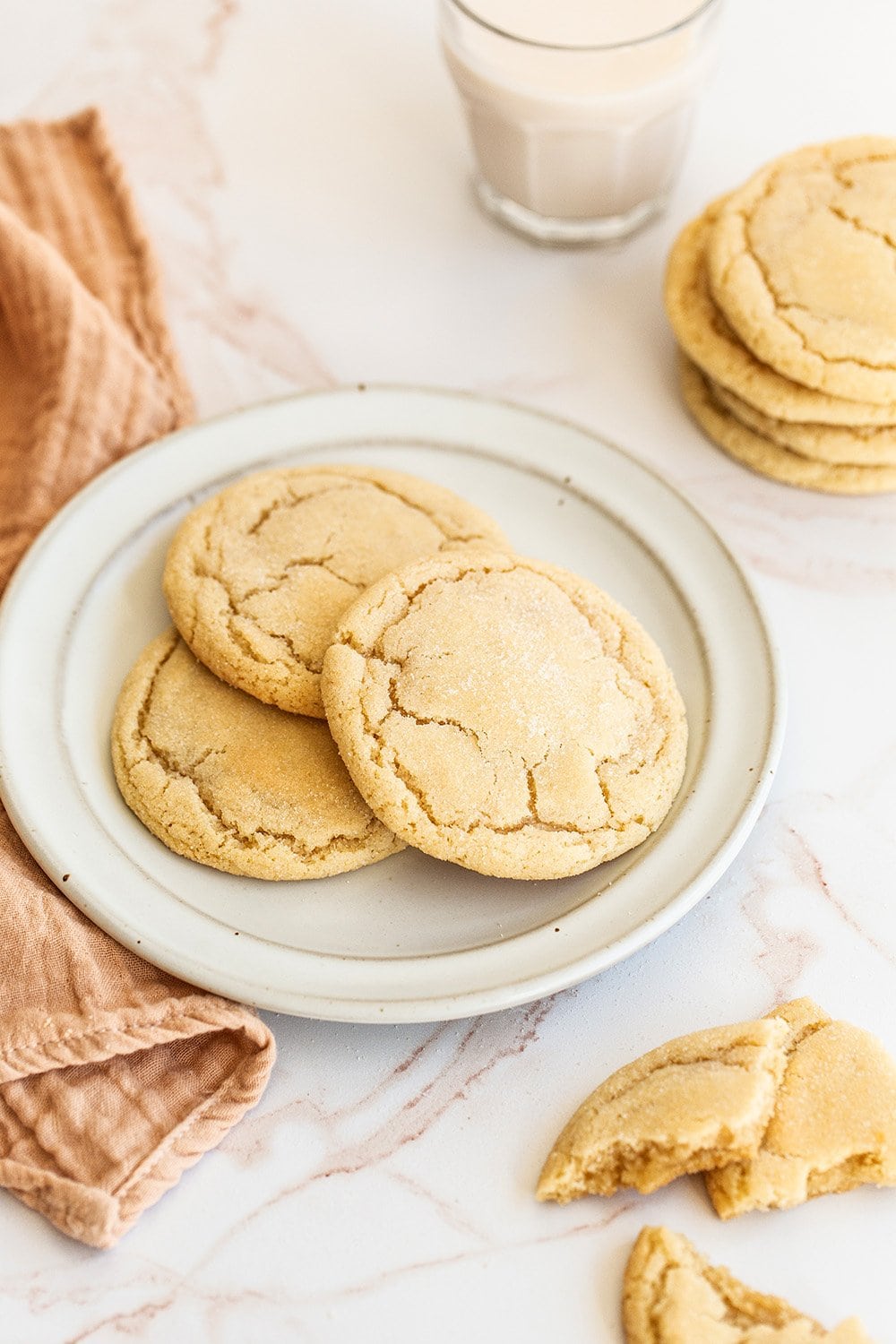 my sugar cookie recipe, baked and sitting on a plate next to a glass of cold milk, ready to enjoy