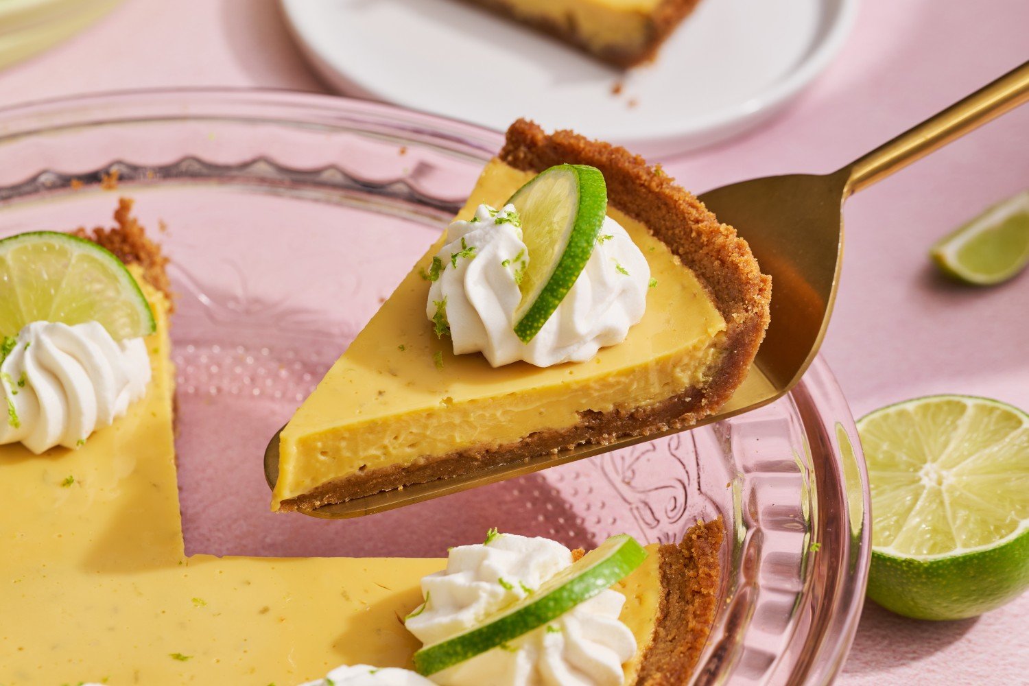 a slice of key lime pie being cut from the pie pan, ready to serve.