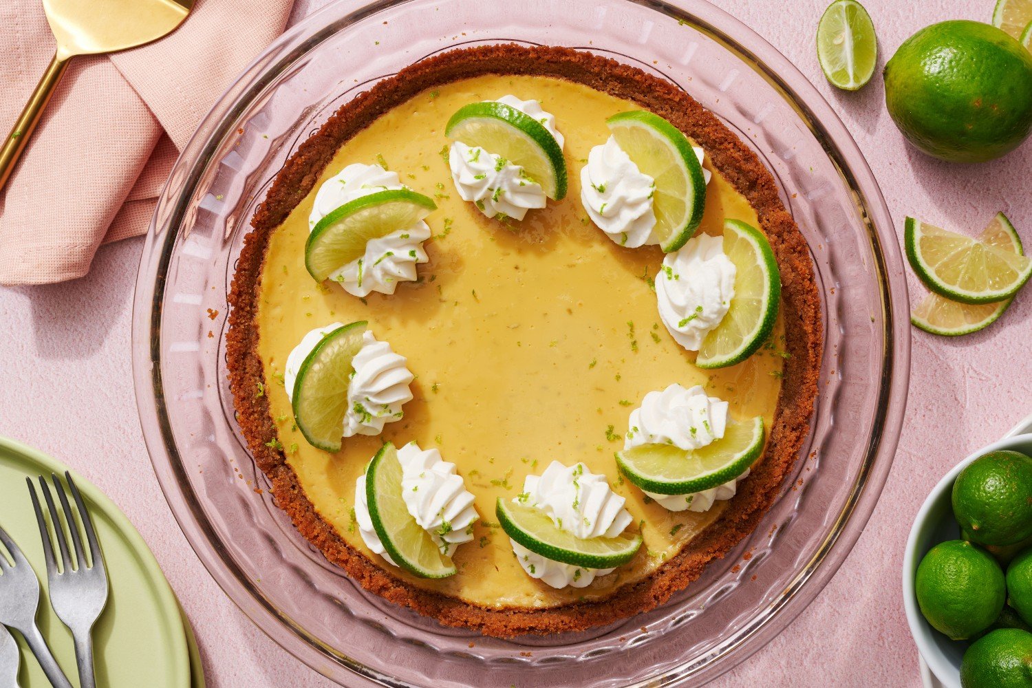 a whole baked key lime pie topped with whipped cream and fresh lime slices.