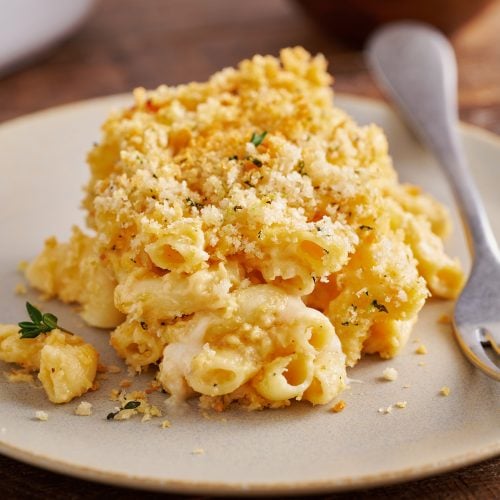 a scoop of mac and cheese on a plate with a fork