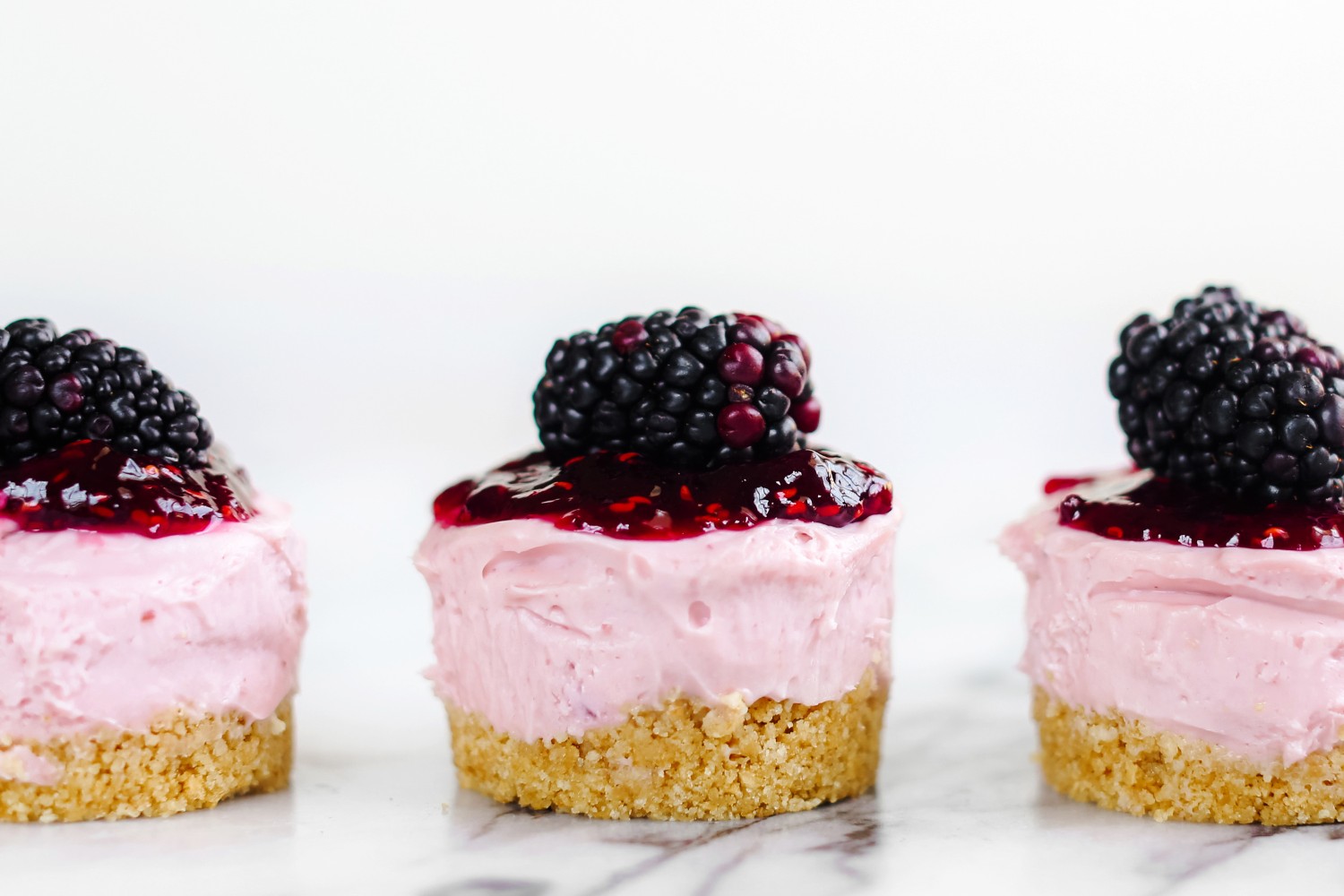 three No Bake Mini Blackberry Cheesecakes in a row.