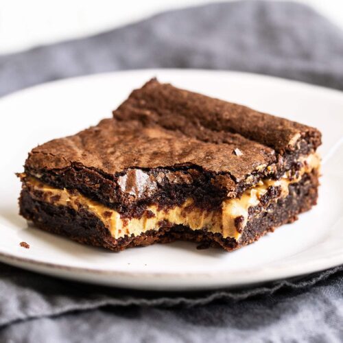 Homemade chocolate fudge brownie stuffed with gooey peanut butter on a plate with a bite taken out