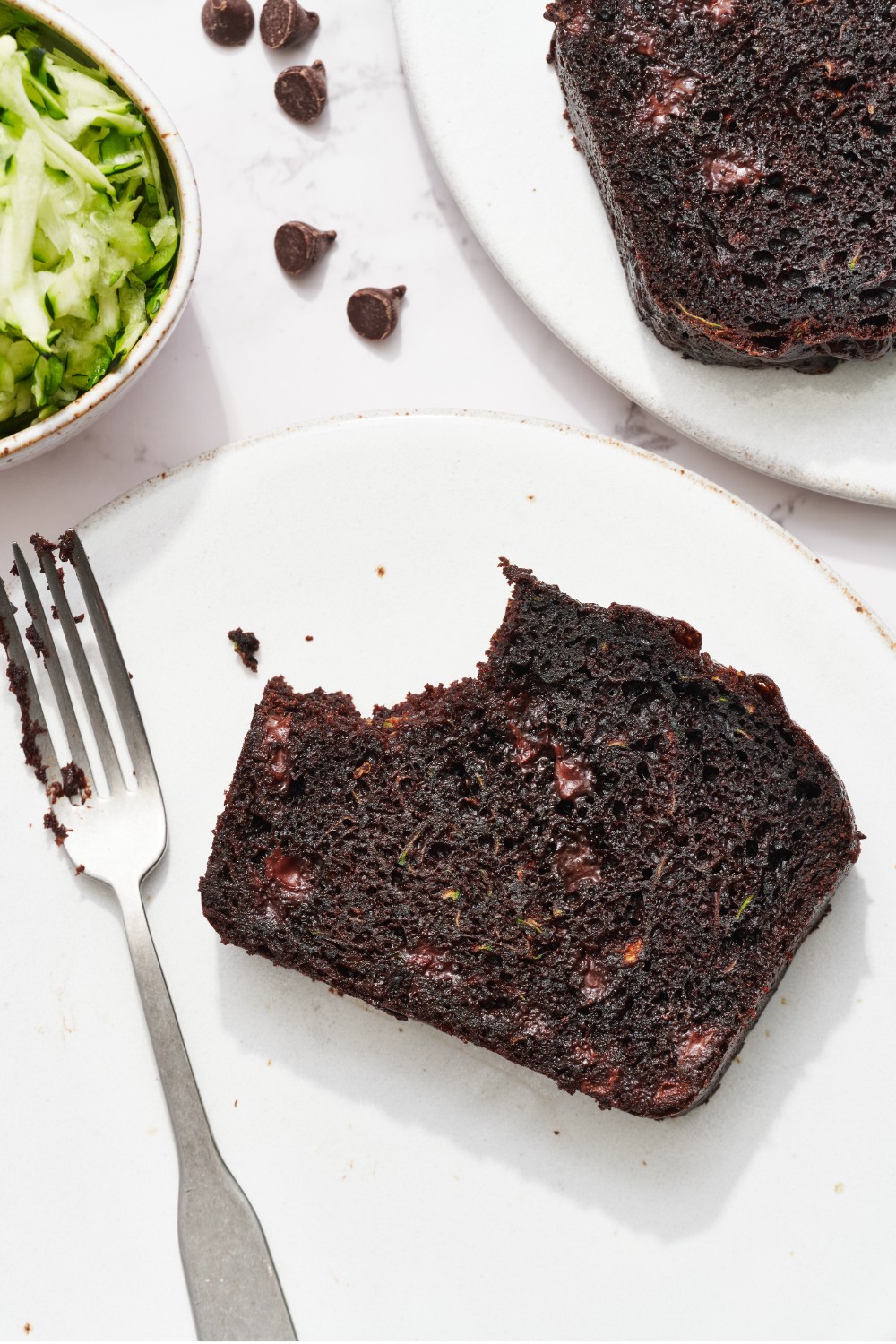 a slice of the quickbread on a plate with a fork, with a bite taken out.