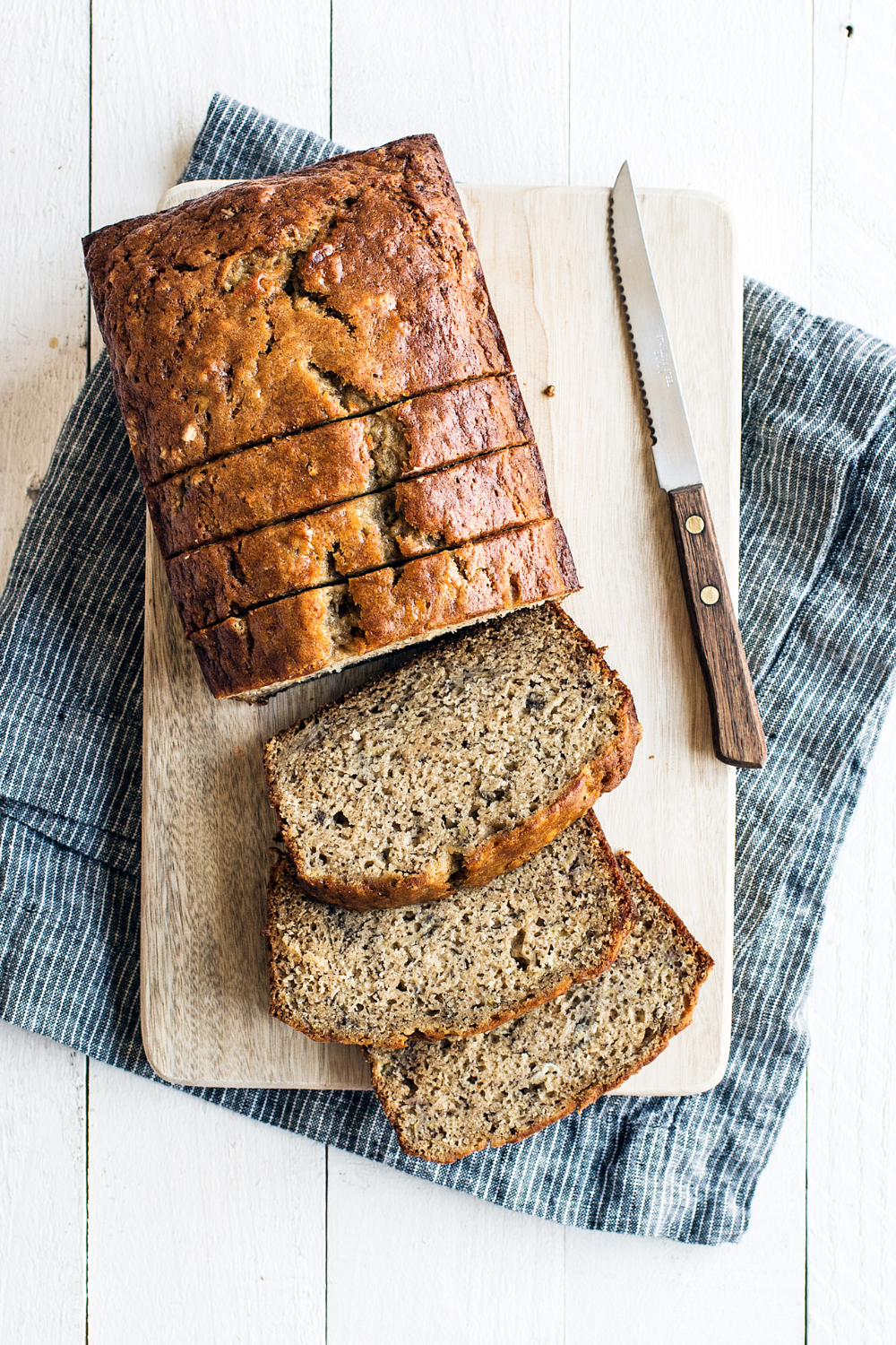 slices of super moist banana bread on a wooden cutting board