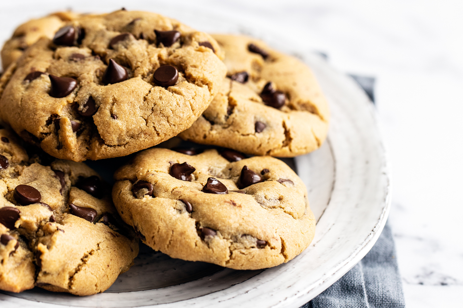 several peanut butter chocolate chip cookies on a plate, ready to serve.