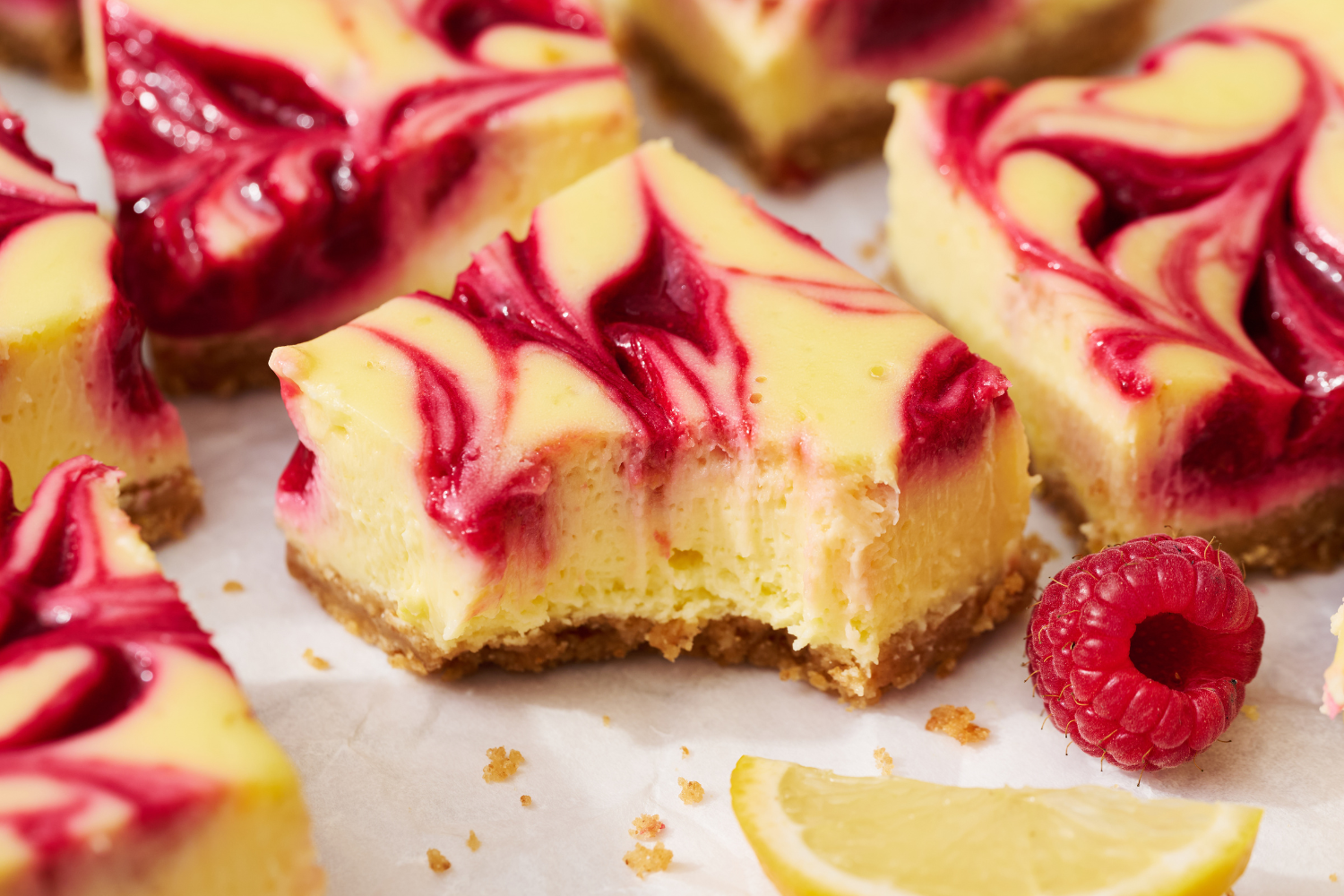 a slice of lemon cheesecake bar with a bite taken out.