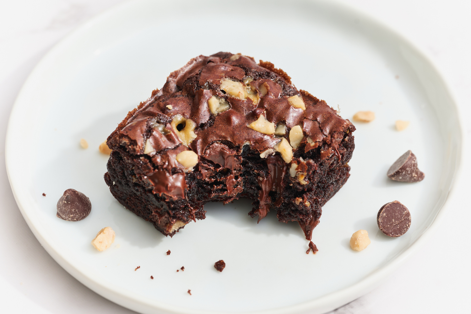 a slice of toffee brownie on a plate with a bite taken out.