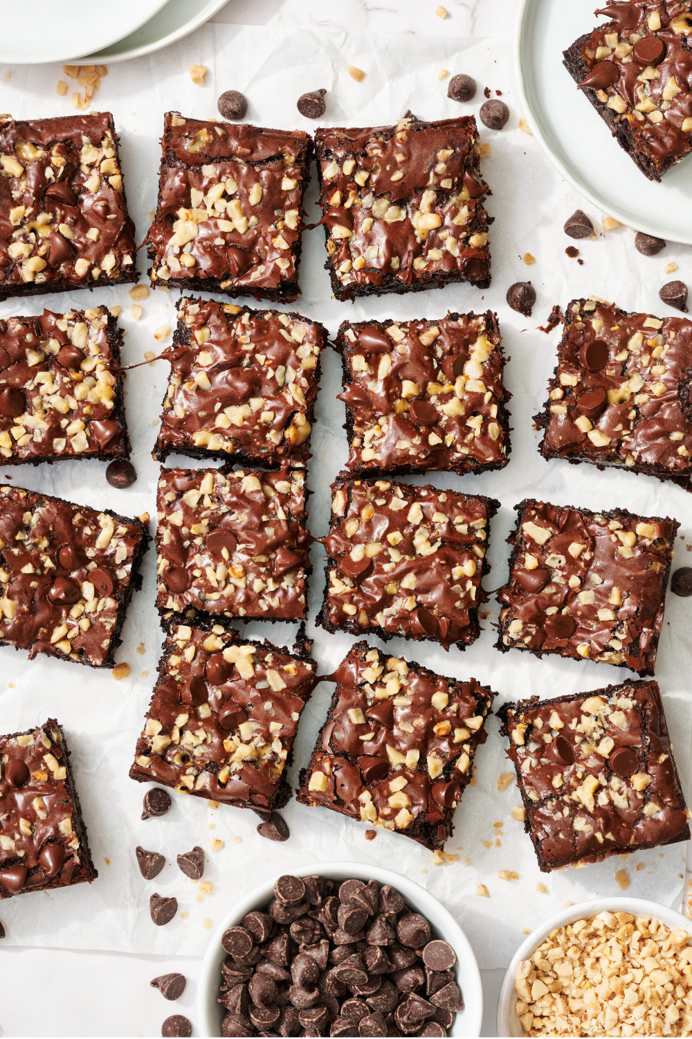 slices of toffee brownie on parchment paper, with some chocolate chips scattered around.